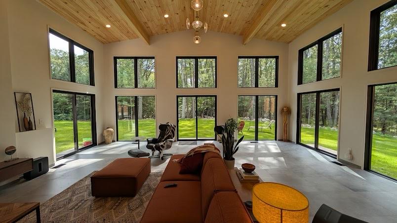 Living room with wood ceiling and large windows