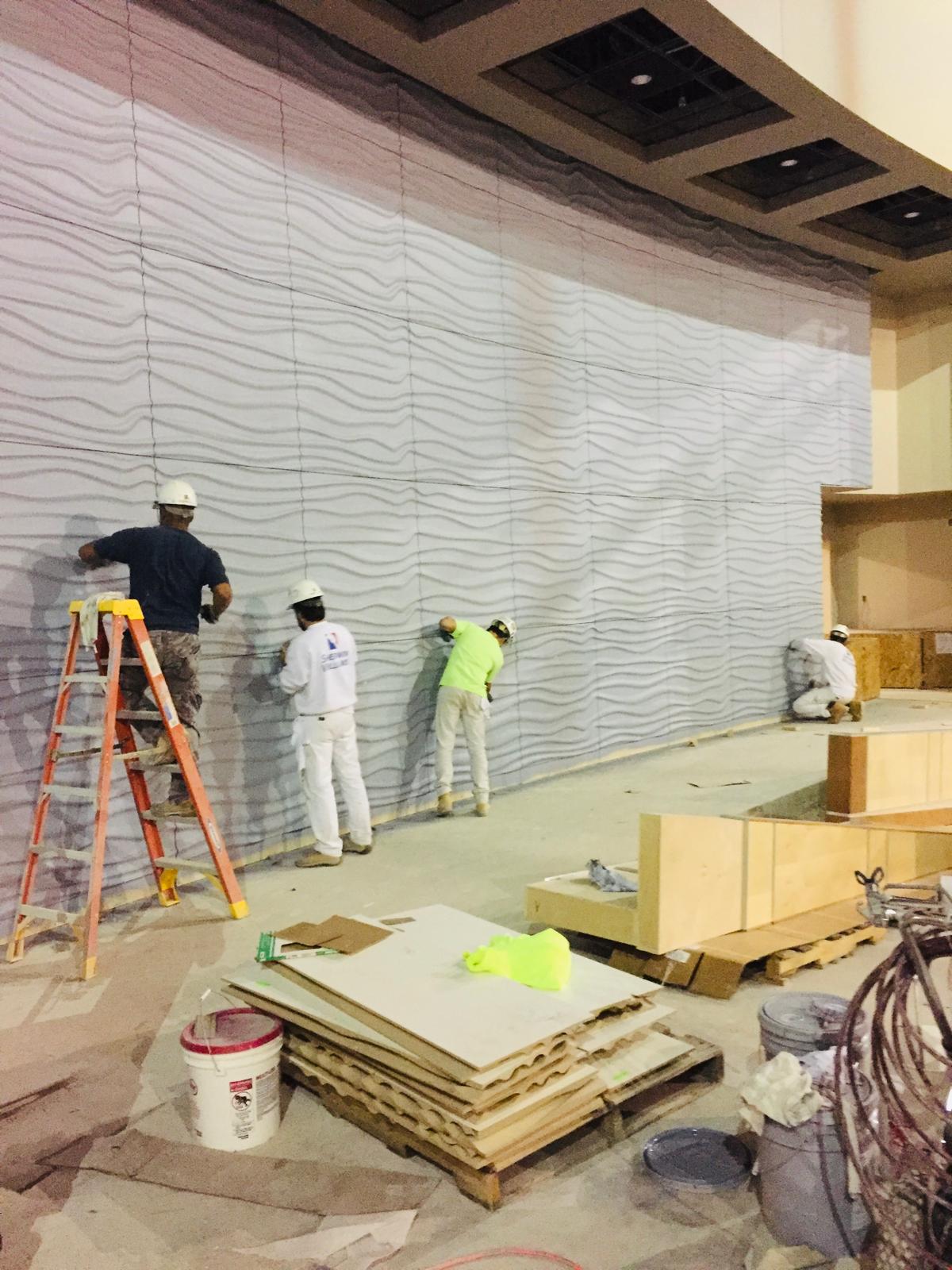 Workers finishing a textured interior wall